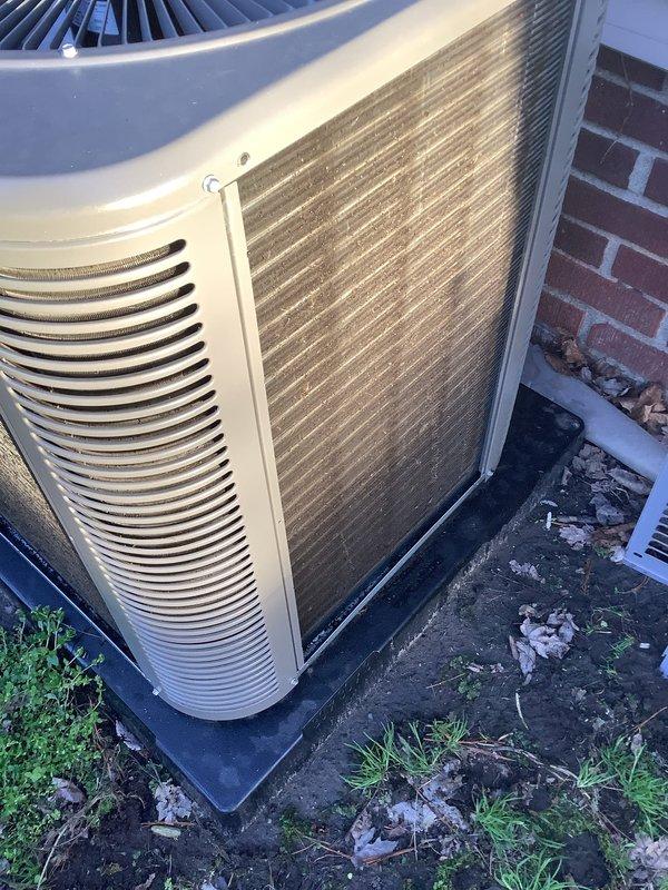 # HVAC Maintenance - Air Conditioning Unit

Performed routine annual maintenance on residential outdoor condensing unit. Conducted thorough inspection of equipment, noting significant dirt accumulation and weathering on exterior panels and condenser coil fins. The unit displayed heavy soiling with dark brown and grayish buildup throughout the fin section, indicating extended operation without recent cleaning.

Completed standard maintenance protocol including filter replacement and condenser pad inspection. The black rubber mounting pad was confirmed to be in serviceable condition providing adequate equipment support. Documented equipment condition through photographic records showing visible wear patterns, panel discoloration, and environmental debris accumulation around the unit base. Unit remains operational following maintenance completion.