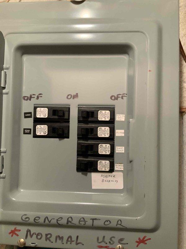Conducted on-site assessment for mini split air conditioning system installation in master bedroom with no existing HVAC system present. Evaluated electrical infrastructure including main 120-volt circuit breaker panel and generator transfer switch configuration. Documented existing electrical capacity and panel layout to determine feasibility of dedicated circuit installation for mini split unit. Photographed electrical panels showing current circuit distribution with master bedroom circuit identified, as well as secondary load center with generator integration. Assessment confirmed adequate wall access and electrical service capacity for expedited mini split installation.