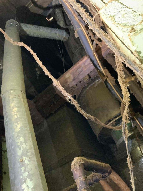 Provided estimate for replacement of leaking 40-gallon natural draft water heater. Inspected existing Lochinvar unit installed in exposed wall cavity with deteriorated surrounding structure and aging plumbing connections including galvanized and copper piping. Assessed installation location, venting configuration, and structural conditions to prepare quote for standard tank-style water heater replacement.
