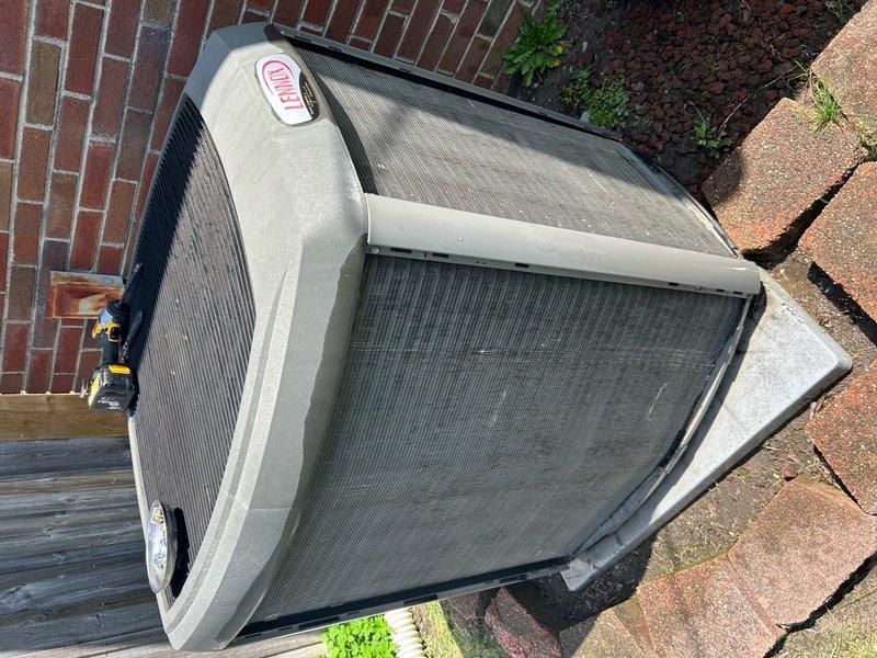 Completed annual cooling maintenance on Lennox outdoor condensing unit. Performed comprehensive system inspection, documented equipment condition with photographs showing unit positioned on concrete pad against brick wall with adequate clearance. Observed dirt and debris accumulation on internal components including condenser coil and compressor; cleaned and serviced unit per manufacturer specifications. Verified protective grilles and housing intact with normal outdoor weathering. All components operating within normal parameters upon completion of maintenance procedures.