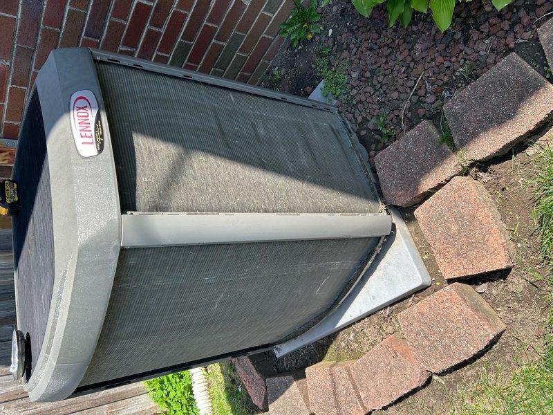 Completed annual cooling maintenance on Lennox outdoor condensing unit. Performed comprehensive system inspection, documented equipment condition with photographs showing unit positioned on concrete pad against brick wall with adequate clearance. Observed dirt and debris accumulation on internal components including condenser coil and compressor; cleaned and serviced unit per manufacturer specifications. Verified protective grilles and housing intact with normal outdoor weathering. All components operating within normal parameters upon completion of maintenance procedures.