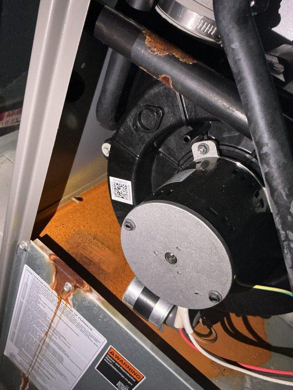 Responded to callback for condensate leak causing cabinet corrosion. Upon inspection, discovered significant rust damage to cabinet plate near vent area due to moisture intrusion from condensate drainage issue. Documented extensive corrosion on orange mounting platform and metal piping components within the air handler cabinet. Photographed affected areas showing oxidation on cabinet surfaces and blower assembly mounting hardware for warranty documentation and future reference.