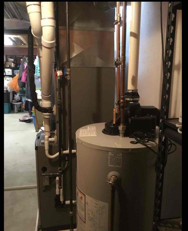 Performed comprehensive water heater assessment in basement utility area for existing Bradford White Defender Safety System unit that was operational but experiencing performance issues. Evaluated current installation configuration including copper supply piping, pressure relief valve, expansion tank mounted on top of unit, shut-off valves, and venting system to determine replacement specifications. Documented existing natural draft or power vent setup, photographed current equipment layout including proximity to HVAC system and available clearances, and provided estimate for new water heater installation to restore optimal hot water delivery and system efficiency.