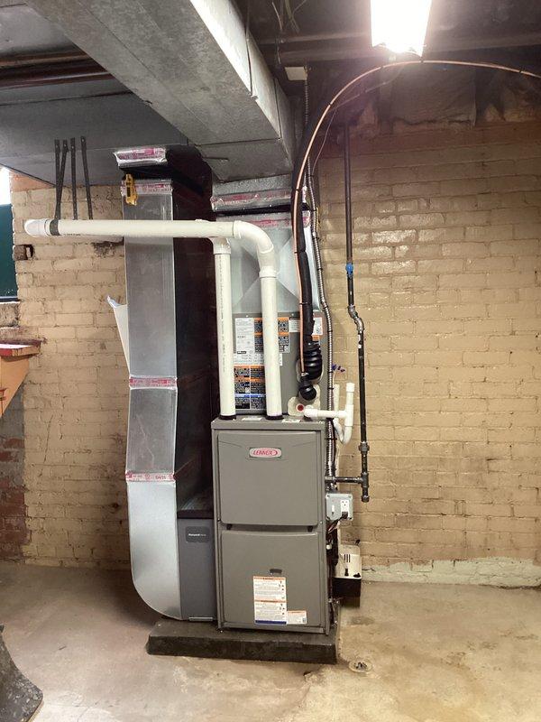 Completed full HVAC system installation including a Lennox 70,000 BTU furnace and 2-ton air conditioning unit with rear discharge configuration. Installed new chimney liner for proper venting, ran white PVC condensate drainage lines, and routed copper refrigerant lines with insulation from basement furnace location to outdoor condenser unit. Secured all piping and electrical conduit to manufacturer specifications, installed condensate pump with floor drain connection, and reconnected all existing ductwork to new equipment. Obtained mechanical and electrical permits prior to installation. System tested and operational upon completion.