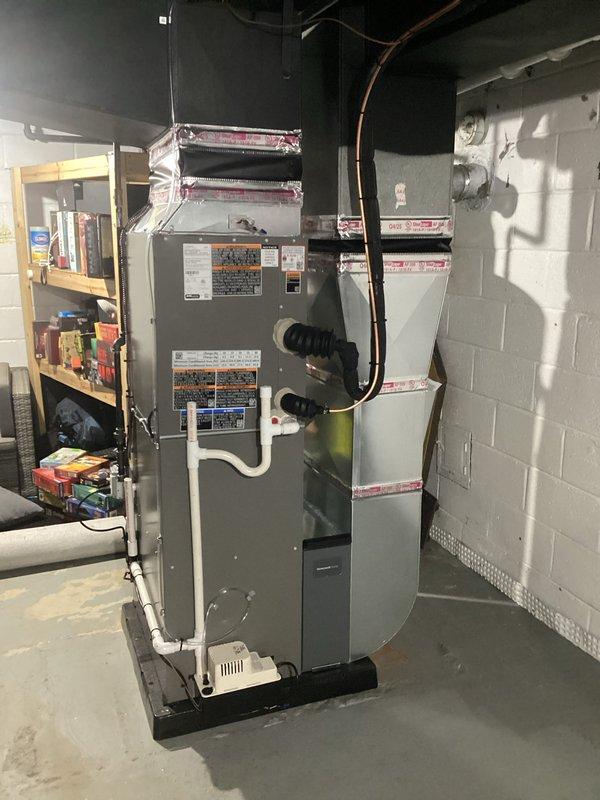 Successfully installed complete HVAC system consisting of 70,000 BTU furnace and 2-ton air conditioning unit in left-side configuration. Installation included mounting furnace with evaporator coil assembly, routing copper refrigerant lines to outdoor condenser, and installing vertical PVC venting system. Connected black flexible ductwork, positioned unit on drain pan, and completed all electrical reconnections per mechanical and electrical permits. System tested and operational.