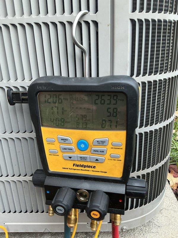 Completed annual cooling maintenance on residential split system. Connected manifold gauges to measure refrigerant pressures and temperatures, verified system operating temperatures of 120.0°F and 26.33°F, inspected outdoor condensing unit condition, and replaced air filter per maintenance protocol.