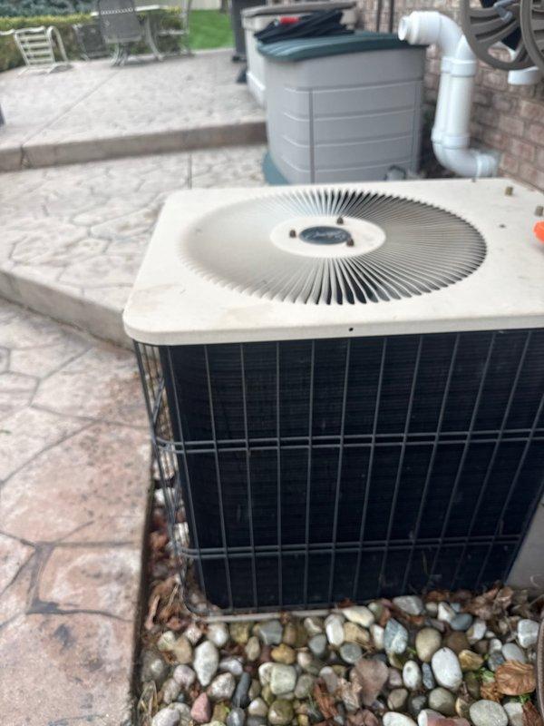 Completed annual cooling maintenance on residential air conditioning system. Performed comprehensive inspection of outdoor condenser unit, verified proper operation of fan motor and compressor, checked refrigerant levels, and cleaned debris from around unit base and stone paver area. Documented equipment condition with photos showing normal weathering and standard operating status for outdoor installation.