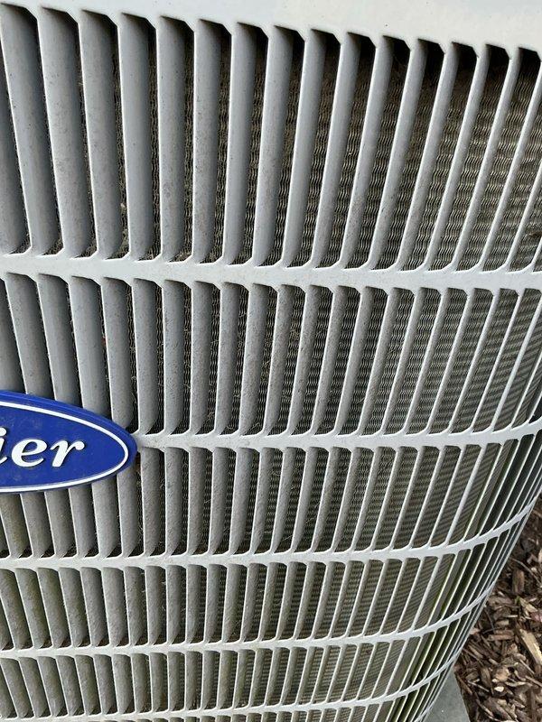 Completed annual HVAC maintenance on Carrier system, performing electrical diagnostics with multimeter to verify proper voltage and component operation at indoor air handler unit. Inspected outdoor condenser unit, noting cooling fins in acceptable condition with minor dust accumulation typical of normal operation, and confirmed filter replacement needed per maintenance schedule.