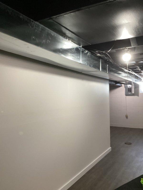 Conducted on-site assessment for Level 2 EV charger installation on exterior side of residence. Evaluated existing electrical infrastructure in basement mechanical space, including main service panel location, available breaker capacity, and optimal routing path for new 240V dedicated circuit. Documented current conditions of unfinished basement area with exposed ductwork and finished lower-level space to determine most efficient conduit run from electrical panel to proposed exterior charging station location. Provided recommendations for wire gauge, circuit breaker sizing, and installation methodology to meet NEC requirements for EV charging equipment.