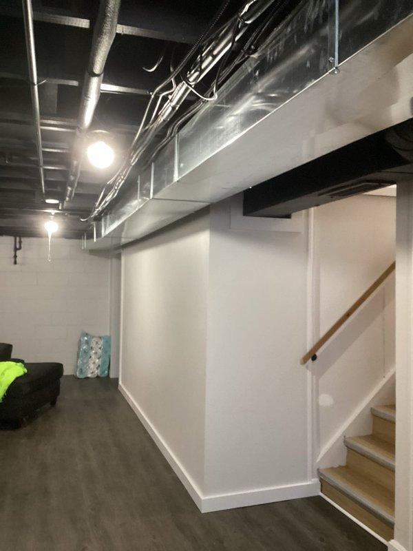 Conducted on-site assessment for Level 2 EV charger installation on exterior side of residence. Evaluated existing electrical infrastructure in basement mechanical space, including main service panel location, available breaker capacity, and optimal routing path for new 240V dedicated circuit. Documented current conditions of unfinished basement area with exposed ductwork and finished lower-level space to determine most efficient conduit run from electrical panel to proposed exterior charging station location. Provided recommendations for wire gauge, circuit breaker sizing, and installation methodology to meet NEC requirements for EV charging equipment.