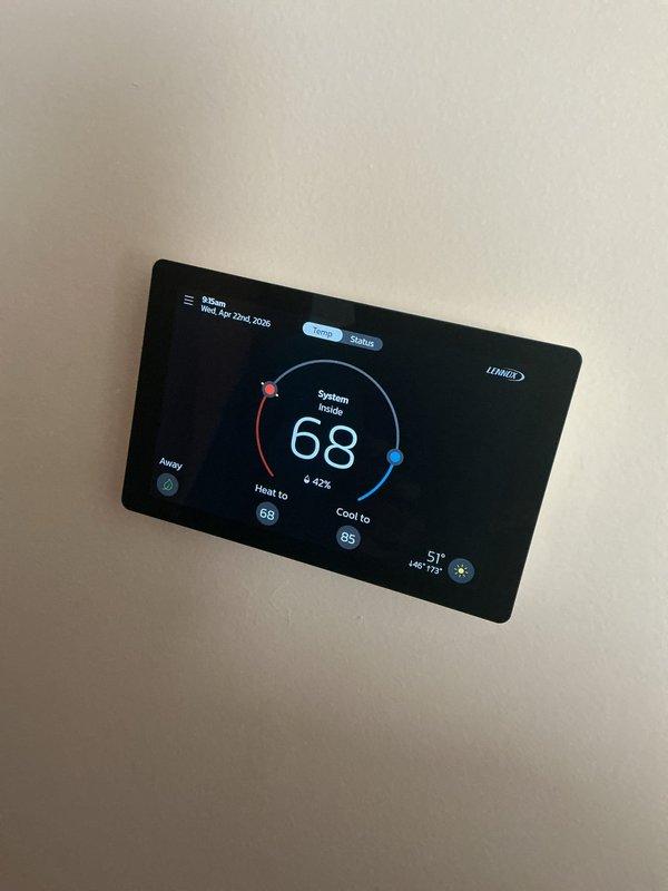 Completed annual cooling maintenance on residential HVAC system. Inspected and photographed furnace unit with internal heat exchanger showing normal dust accumulation on honeycomb filter element. Verified Lennox smart thermostat operation with system maintaining 68°F heating setpoint and 85°F cooling setpoint, displaying proper humidity reading of 42%. All equipment operating within normal parameters with no deficiencies noted.