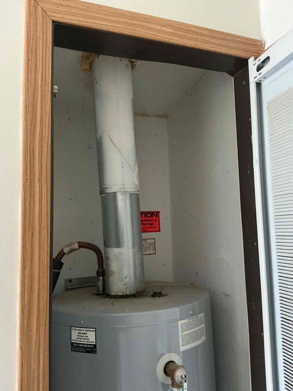 Completed on-site assessment for standard water heater replacement estimate. Inspected existing residential water heater installation, documented current unit specifications, venting configuration with PVC and metal flue piping, utility connections including copper supply lines, pressure relief valve, and drain valve assembly. Current unit is operational and properly vented through vertical chase system in closet installation.