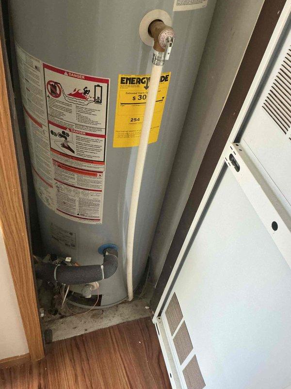 Completed on-site assessment for standard water heater replacement estimate. Inspected existing residential water heater installation, documented current unit specifications, venting configuration with PVC and metal flue piping, utility connections including copper supply lines, pressure relief valve, and drain valve assembly. Current unit is operational and properly vented through vertical chase system in closet installation.