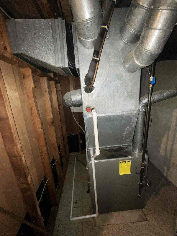 Conducted on-site evaluation of 13-year-old residential air conditioning system to provide replacement estimate. Documented existing HVAC equipment configuration in basement mechanical room, including current furnace unit, ductwork layout, and system connections. Assessed accessibility for equipment removal and new installation, noting concrete floor workspace, overhead joist clearances, and stairwell access considerations for equipment delivery.