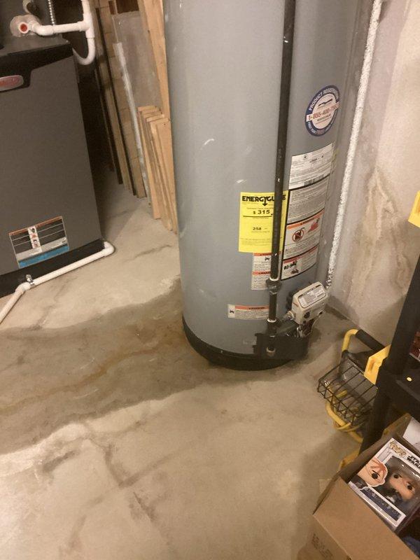 Responded to no hot water complaint affecting entire house. Upon inspection, found existing tanked water heater in basement utility area with active leak at base of unit, resulting in moisture staining on concrete floor and complete loss of hot water supply. Assessed water heater condition, verified leak source, and documented equipment specifications and surrounding mechanical systems. Photographed affected unit showing manufacturer labels, Energy Guide sticker, and evidence of water damage to floor surface. Evaluated venting system, plumbing connections, and electrical components. Provided customer with findings and replacement recommendations due to tank failure.