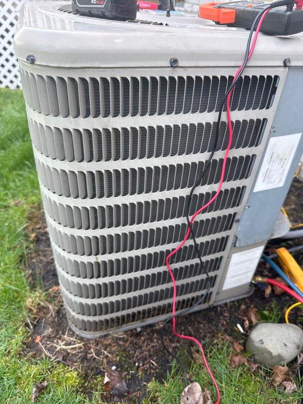 Completed annual HVAC maintenance on outdoor condenser unit, performing diagnostic testing with digital meter and checking electrical connections. Unit showed normal operating condition with no visible damage or unusual wear, and all systems tested within acceptable parameters.