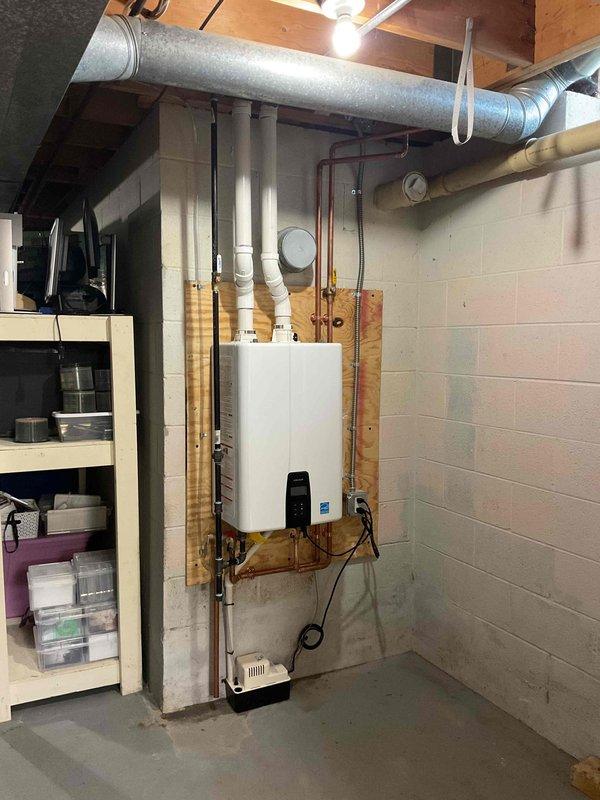 Completed full installation of tankless water heater unit in basement mechanical room, including wall mounting, hot and cold water supply connections with copper piping, gas line reconnection, and proper venting system installation. Installed exterior PVC vent piping with appropriate termination cap and intake configuration through foundation wall per manufacturer specifications. All required mechanical permits were obtained prior to installation, system was pressure tested, and unit was commissioned to verify proper operation and safety controls.