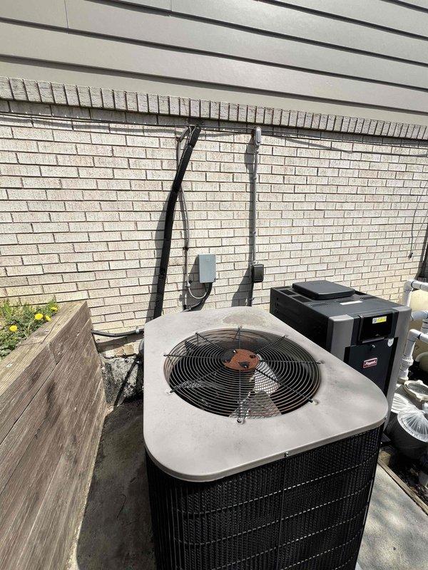 Provided estimate for complete replacement of 18-year-old non-operational furnace and air conditioning system currently located in basement. Evaluated existing outdoor condenser unit and associated refrigerant lines running along exterior brick wall, noting equipment positioned on concrete pad with electrical disconnect box and conduit routing. Assessed installation requirements for new HVAC system to restore heating and cooling functionality to the residence.