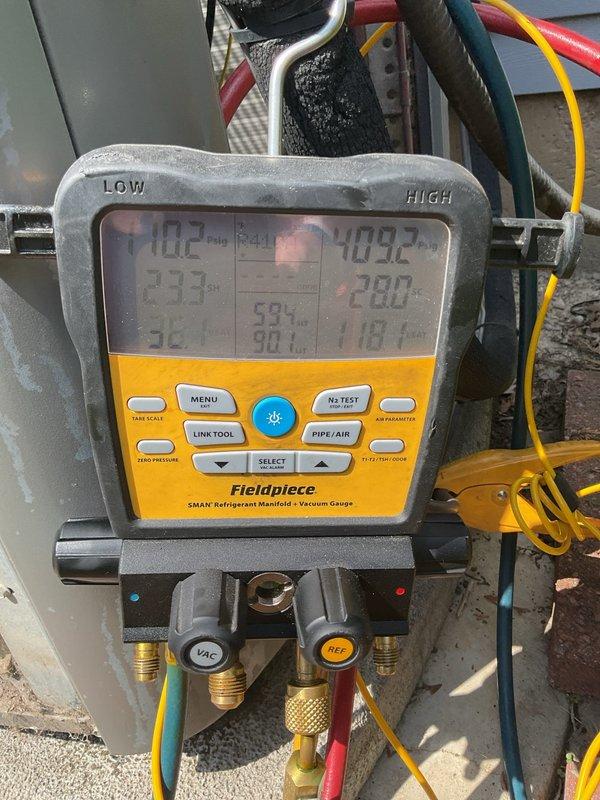 Responded to service call for Lennox air conditioning system displaying error code 411 and non-functional humidifier. Upon arrival, performed diagnostic assessment of outdoor condensing unit which showed signs of age and debris accumulation on coil surfaces and ventilation grilles. Connected Fieldpiece SMAN refrigerant manifold and vacuum gauge to system to evaluate refrigerant pressures and temperatures. Diagnostic readings indicated low-side temperature of 102°F and high-side temperature of 403°F with associated pressure values. Assessed overall system performance and identified maintenance needs including cleaning of condenser coil and filtration components. Documented equipment condition through photography showing weathered exterior cabinet, dirt buildup on mesh screens, and general need for preventive maintenance. Evaluated humidifier integration with HVAC system to address reported malfunction. Provided technical findings and recommendations for restoring proper operation of bot
