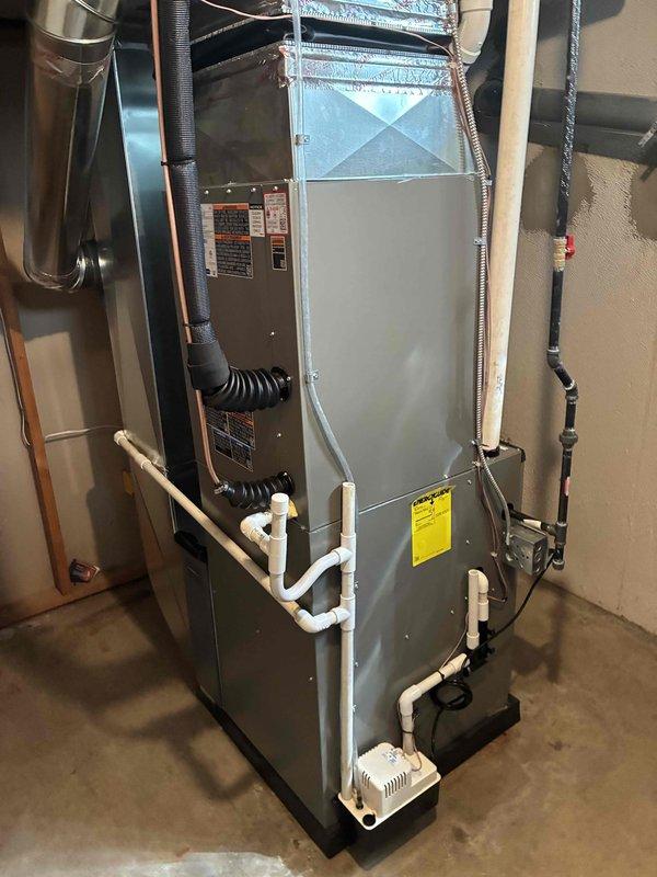 Completed full HVAC system installation including a 90,000 BTU gas furnace and 3.5 ton air conditioning unit with rear discharge configuration. Installed new furnace in basement on equipment platform with proper venting via PVC piping and connected supply and return ductwork. Mounted outdoor condensing unit on concrete pad with electrical disconnect and proper refrigerant line connections. Added whole-home humidifier to system and reconnected all existing ductwork to new equipment. All mechanical, refrigeration, and electrical connections completed per manufacturer specifications and local code requirements. System tested and verified operational.