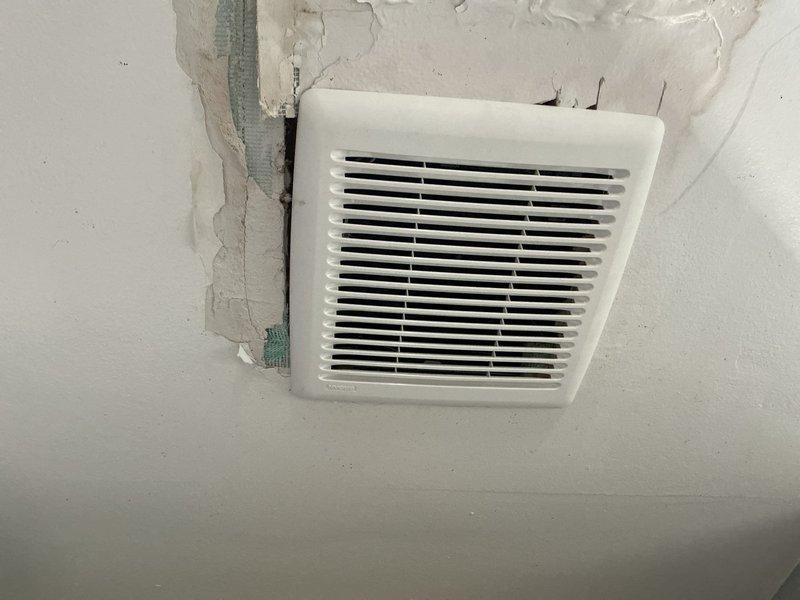 Manager conducted site visit to assess ceiling damage and non-functional exhaust fan following recent furnace and air conditioning installation. Upon inspection, determined exhaust fan required removal and return to shop for evaluation, with visible ceiling deterioration observed around ventilation grille and exposed ductwork connection. Documented damage with photos showing displaced vent cover and compromised ceiling material for warranty claim processing.