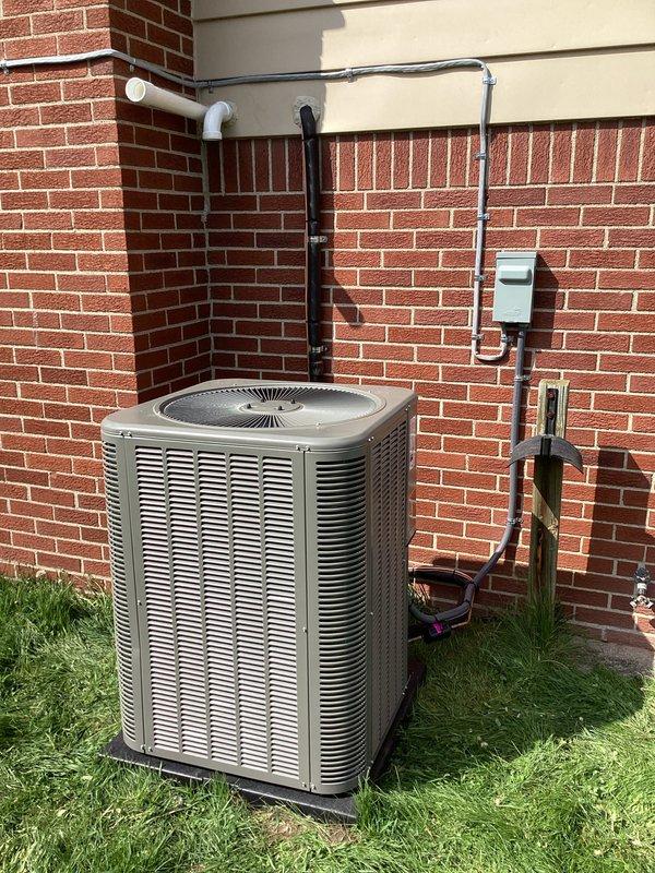 Completed full HVAC system installation including a 90,000 BTU furnace with humidifier and 3.5-ton air conditioning unit with rear discharge configuration. Installed outdoor condenser unit on pad against brick exterior wall with proper refrigerant line routing, electrical disconnect, and PVC condensate drainage system. All components professionally mounted with secure conduit runs, proper insulation on refrigerant lines, and code-compliant electrical connections reconnected to existing service.