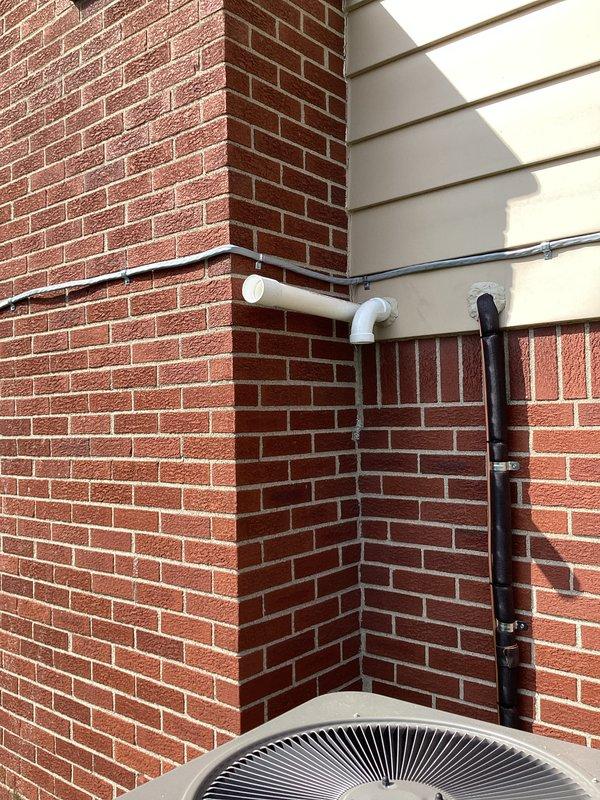 Completed full HVAC system installation including a 90,000 BTU furnace with humidifier and 3.5-ton air conditioning unit with rear discharge configuration. Installed outdoor condenser unit on pad against brick exterior wall with proper refrigerant line routing, electrical disconnect, and PVC condensate drainage system. All components professionally mounted with secure conduit runs, proper insulation on refrigerant lines, and code-compliant electrical connections reconnected to existing service.