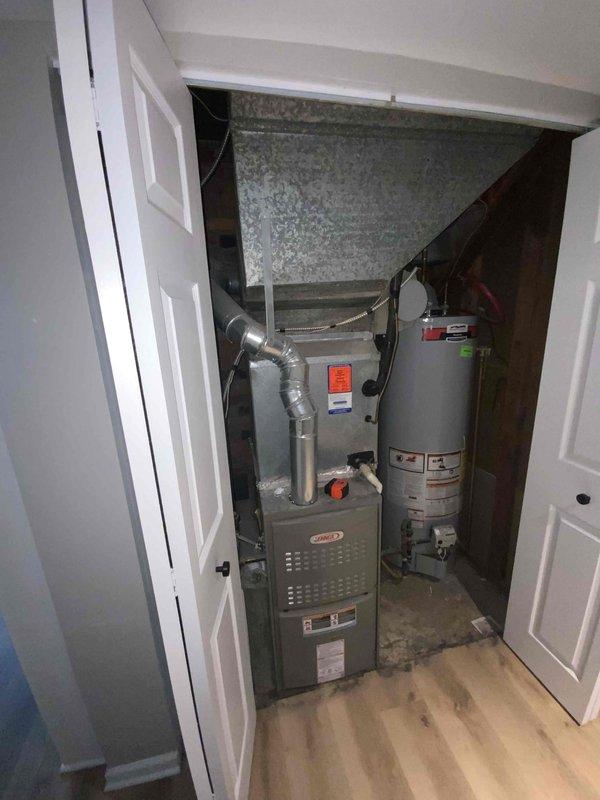 Completed on-site assessment for air conditioning system replacement estimate. Existing AC unit confirmed to be over 15 years old and requiring full replacement due to age and declining performance. Documented current HVAC equipment configuration including Lennox furnace installation in utility closet with connected ductwork and plenum, as well as basement air handling components with flexible ducting. Photographed existing system layout to support replacement proposal and equipment specifications.