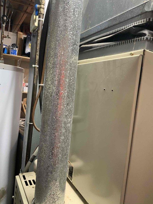 Conducted comprehensive assessment of existing HVAC system for full replacement estimate. Evaluated 31-year-old original furnace and air conditioning unit from 1995, both at end of serviceable life. Inspected furnace with perforated metal grille panel and diagonal ventilation pattern in basement utility area. Examined ductwork showing significant dust accumulation and surface discoloration indicating age-related deterioration. Assessed air handler components and ventilation infrastructure. Documented existing equipment configuration, duct connections, and overall system condition through photographic documentation. Provided detailed estimate for complete furnace and air conditioner replacement to restore efficient climate control operation.