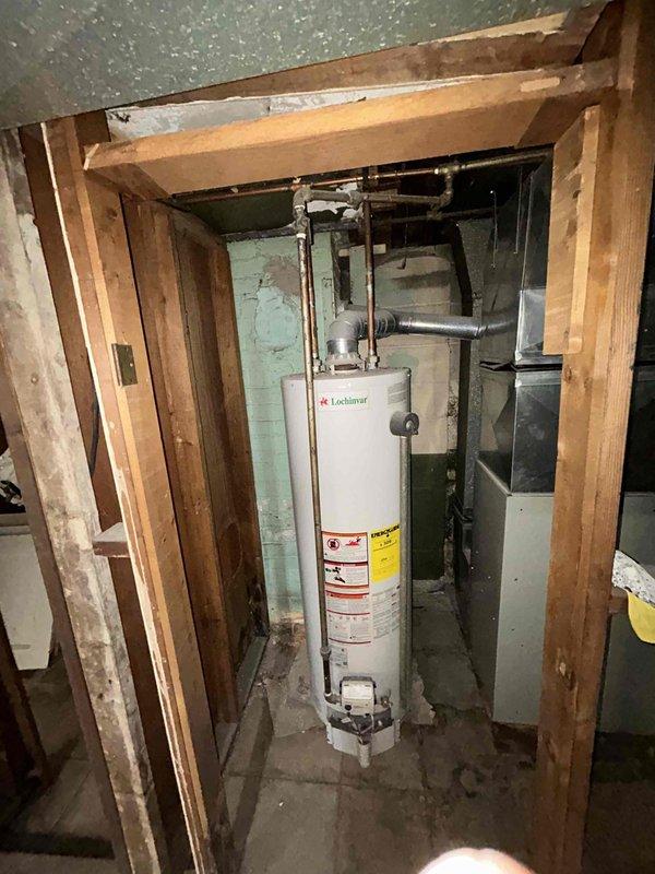 Provided estimate for complete HVAC system replacement in basement location, including new furnace and cooling unit for small to mid-sized residential space (0-1200 sq.ft.). Assessed existing utility room with water heater and determined electrical panel upgrade required to support new equipment installation. Documented current basement mechanical room configuration with exposed framing, existing ductwork, and available installation space for proposed system components.
