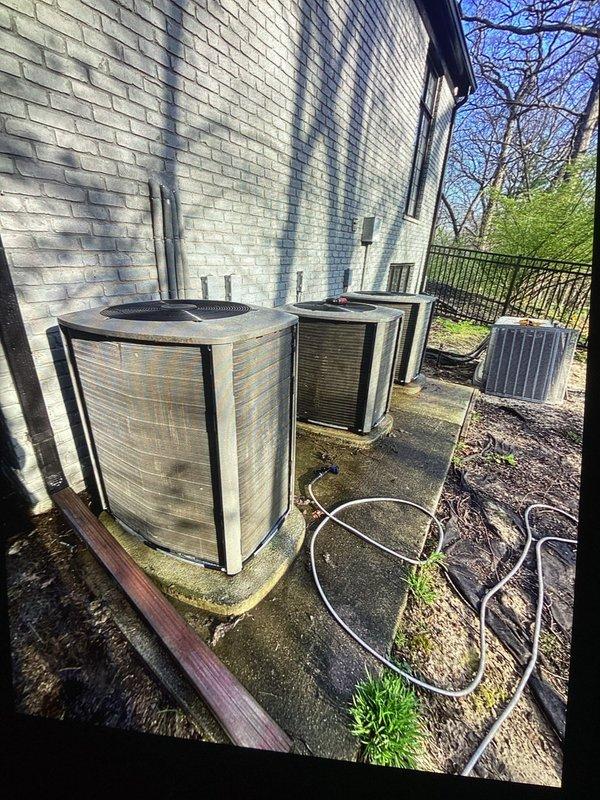 Completed annual spring maintenance on multiple HVAC systems at a multi-unit property, servicing four outdoor condensing units positioned along the building's exterior. Performed comprehensive tune-up procedures on all AC units including visual inspection of equipment condition, verification of proper refrigerant line connections, assessment of electrical conduit installations, and evaluation of unit mounting and pad conditions. Documented equipment placement and overall system configuration with photographic records showing all units operational and properly positioned with adequate clearance for airflow and future maintenance access.