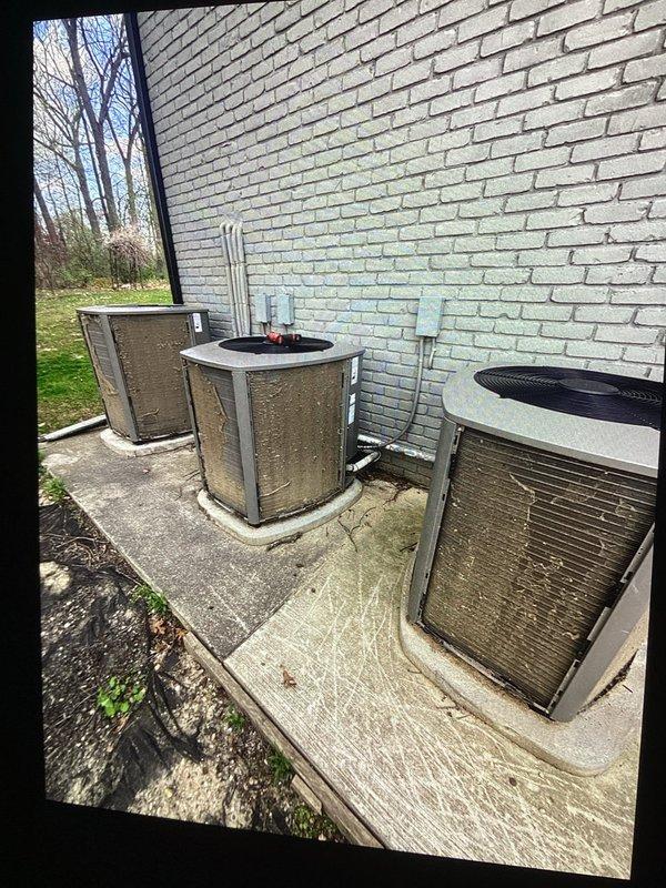 Completed annual spring maintenance on multiple HVAC systems at a multi-unit property, servicing four outdoor condensing units positioned along the building's exterior. Performed comprehensive tune-up procedures on all AC units including visual inspection of equipment condition, verification of proper refrigerant line connections, assessment of electrical conduit installations, and evaluation of unit mounting and pad conditions. Documented equipment placement and overall system configuration with photographic records showing all units operational and properly positioned with adequate clearance for airflow and future maintenance access.