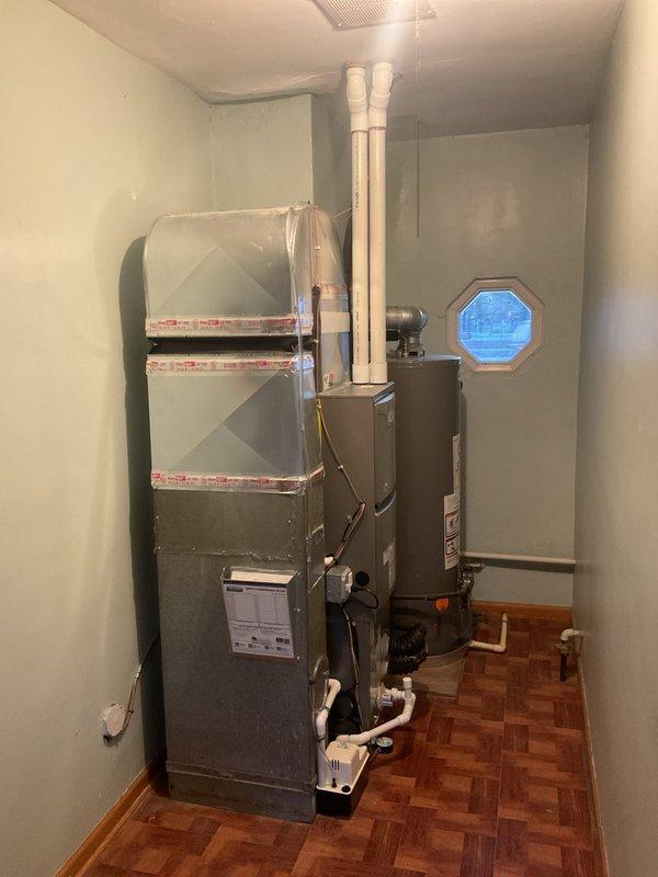 Completed full HVAC system installation including a 70,000 BTU furnace and 2-ton air conditioning unit in residential utility room. Installed new electrical circuit to support equipment, ran white PVC venting from furnace through ceiling, connected copper refrigerant lines between indoor and outdoor units, and installed condensate pump with drainage system. Obtained mechanical and electrical permits prior to installation, positioned furnace with proper clearances adjacent to existing water heater, secured all ductwork connections with insulated flex duct, and verified all gas line connections, electrical wiring, and system controls for safe operation.