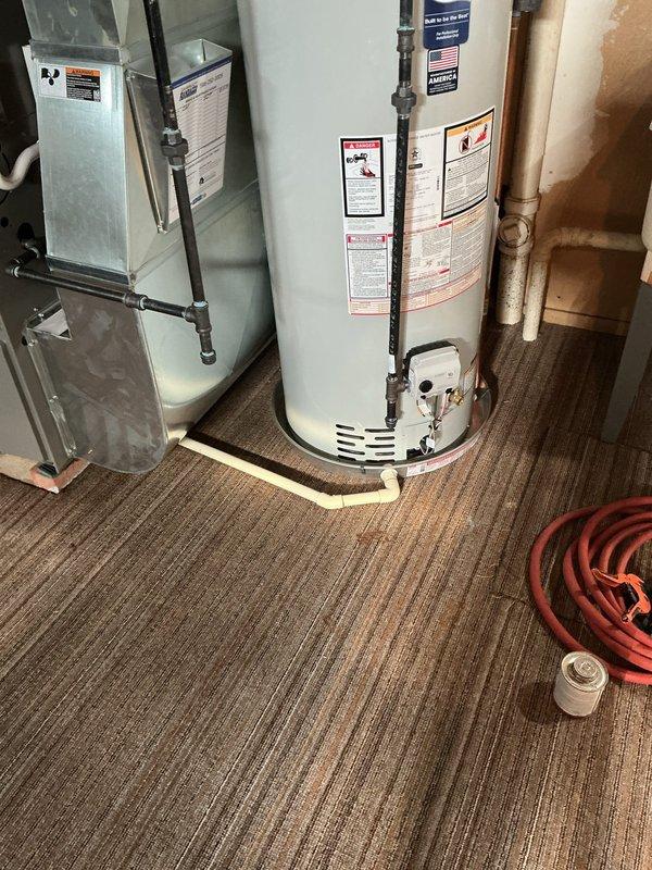 Completed warranty follow-up on recently installed 40-gallon hot water heater. Evaluated existing drain line configuration beneath furnace to determine viability for HWT condensate drainage per customer request. Assessed PVC drain piping layout and verified proper routing capability to accommodate additional drainage from water heater installation. Confirmed mechanical permit compliance and reconnection specifications for hot water heater system in utility room location.