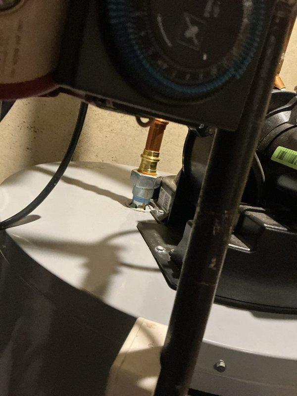 Replaced both rubber washers on the hot water tank to address leaking at pipe penetrations through the drain pan. Removed old deteriorated washers, cleaned the mounting surfaces, and installed new rubber grommets to ensure proper seal and prevent water damage.