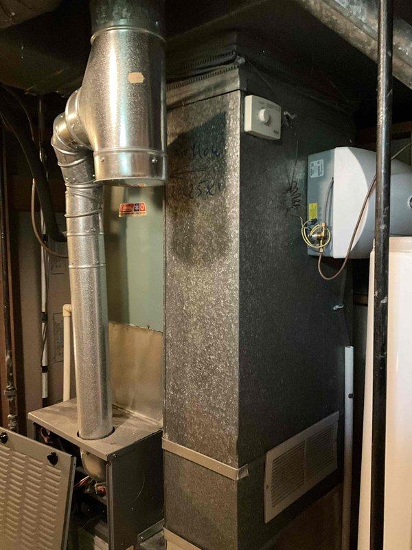 Provided estimate for air conditioning system replacement at residential property with basement-located equipment. Current AC unit is older and operational but nearing end of service life, while furnace is newer and will remain in place. Evaluated existing outdoor condenser unit positioned on concrete pad against brick exterior and indoor air handler with associated ductwork and electrical components in basement utility area.