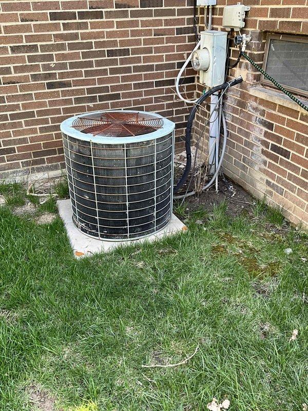 Provided estimate for air conditioning system replacement at residential property with basement-located equipment. Current AC unit is older and operational but nearing end of service life, while furnace is newer and will remain in place. Evaluated existing outdoor condenser unit positioned on concrete pad against brick exterior and indoor air handler with associated ductwork and electrical components in basement utility area.