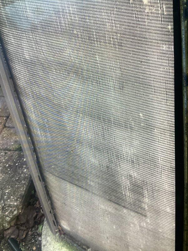 Completed annual cooling maintenance on residential air conditioning system. Inspected condenser unit and identified significant dirt, dust, and debris accumulation on exterior coil fins and mesh panels, along with algae growth at base indicating reduced airflow efficiency. Replaced system filter and documented equipment condition through photographs. Scheduled customer for return air conditioning check next year and provided reminder to arrange annual heating maintenance appointment.