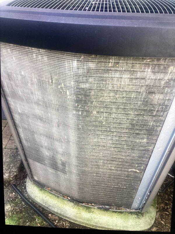 Completed annual cooling maintenance on residential air conditioning system. Inspected condenser unit and identified significant dirt, dust, and debris accumulation on exterior coil fins and mesh panels, along with algae growth at base indicating reduced airflow efficiency. Replaced system filter and documented equipment condition through photographs. Scheduled customer for return air conditioning check next year and provided reminder to arrange annual heating maintenance appointment.