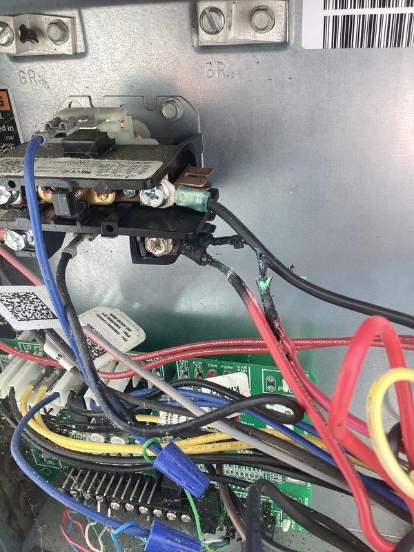 # HVAC Service Report - No Cooling Issue Resolved

Responded to service call for 2-year-old air conditioning system experiencing no cooling condition. Upon arrival, performed initial system diagnostics and visual inspection of outdoor condensing unit and indoor air handler components.

Accessed electrical control panel and thoroughly inspected all control boards, relay assemblies, and wiring connections. Examined black contactor relay with multiple copper terminal connections, verifying proper contact closure and electrical continuity. Tested all wire connections including blue, red, black, and yellow control and power wiring for secure termination and proper voltage readings.

Inspected multiple green printed circuit boards (PCBs) within the control housing, checking for signs of component failure, burned traces, or damaged electronic elements. Verified proper operation of all integrated circuits, capacitors, and resistors on control boards. Examined wiring harnesses and cable routing