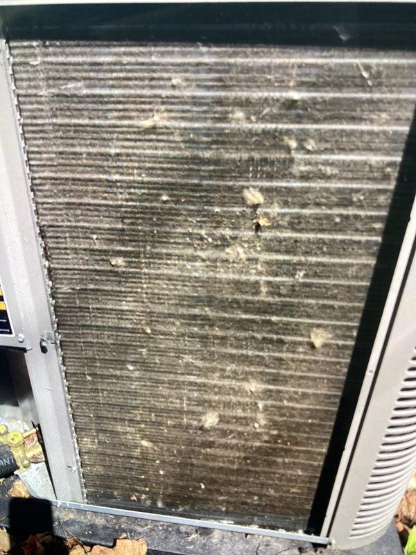 Completed annual cooling maintenance on residential HVAC system. Replaced air filter and humidifier pad as scheduled. Inspected furnace in response to reported popping noise during operation and verified system operation. Documented severely clogged condenser coil with extensive dirt, dust, and debris accumulation restricting airflow through fins. Noted organic material and leaves collected at base of outdoor unit. Condenser coil condition indicates reduced heat transfer efficiency and requires professional coil cleaning to restore optimal system performance.