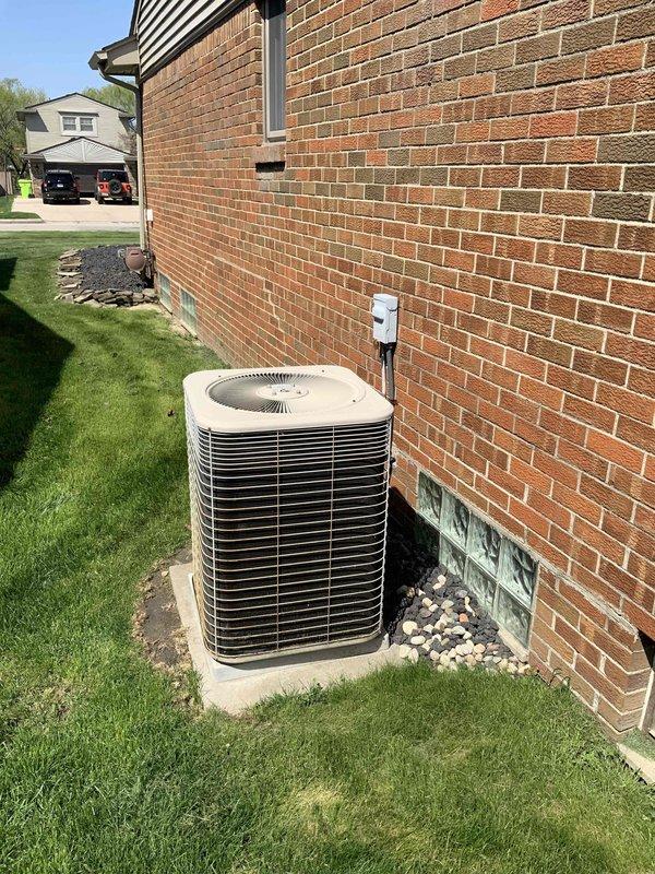 Conducted comprehensive assessment of 24-year-old residential HVAC system for replacement estimate. Evaluated existing furnace located in basement utility area with current water heater and ductwork configuration, and inspected outdoor air conditioning condenser unit positioned on concrete pad against exterior brick wall with glass block basement windows. Documented equipment conditions, spatial constraints, and existing infrastructure including copper piping, electrical panel access, and metal ductwork routing to provide accurate replacement system recommendations and installation requirements.