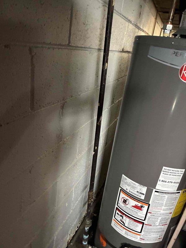 Completed comprehensive whole home plumbing inspection with focus on water heater system in 1957-built residence. Thoroughly examined water heater unit, including all connections, T&P relief valve, combustion chamber access, venting system, and surrounding infrastructure. Inspected PVC venting configuration, brass fittings, and condensate pump operation. Evaluated basement plumbing infrastructure, including visible supply and drain lines, floor conditions for signs of water damage or leaks, and concrete block foundation walls for moisture intrusion. Documented water heater manufacturer labels, safety warnings, and installation specifications. Verified proper clearances around unit and assessed overall condition of aging mechanical systems. No deficiencies, leaks, or safety concerns identified during inspection. All components functioning within normal parameters. Photographic documentation captured for maintenance records.