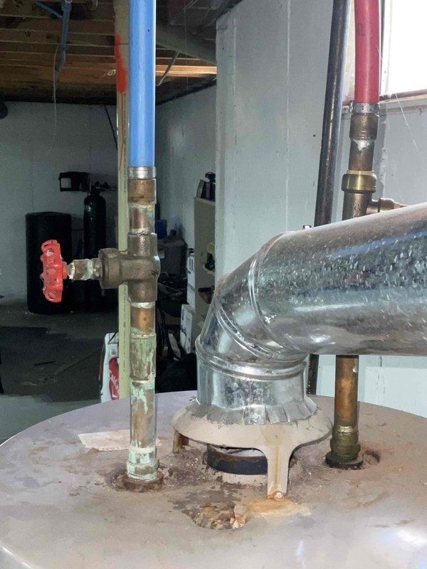 Provided comprehensive estimate for tankless water heater installation in basement utility area where existing standard tank water heater system was non-operational. Assessed current plumbing infrastructure including supply lines with significant mineral buildup visible in piping, evaluated existing pipe routing with insulated hot and cold water lines, and determined requirements for new tankless unit installation including necessary venting, gas line modifications, and electrical connections. Documented existing conditions showing heavy scale deposits in current system and recommended tankless solution as upgrade from previously quoted 40 and 50 gallon standard tank options.