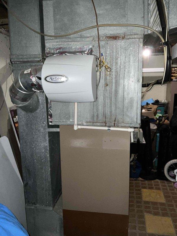 Conducted on-site evaluation of 30-year-old furnace and air conditioning system for replacement estimate at owner-occupied single-family residence. Assessed existing split system configuration including basement-mounted furnace with horizontal ductwork, Aprilaire humidifier integration, and associated copper plumbing connections. Documented current equipment condition, ductwork layout, and utility room infrastructure through photographic documentation to provide accurate replacement system specifications and installation requirements.