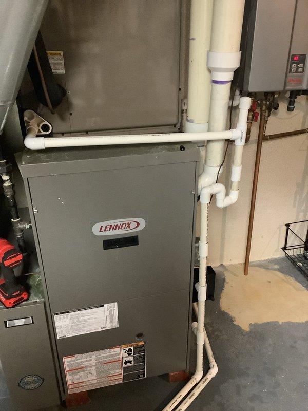 Responded to service call for 18-year-old Lennox furnace leaking water in basement during air conditioning operation. Upon inspection, identified condensate drainage issue causing water accumulation on concrete floor beneath HVAC equipment. Performed diagnostic evaluation of condensate drain lines, cleared blockage in PVC drainage system, and verified proper flow from air handler to drain.