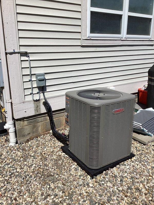 Completed full HVAC system installation including a 90,000 BTU furnace and 3-ton air conditioning unit with rear discharge configuration. Installed outdoor condensing unit on gravel pad with proper drainage, ran electrical conduit and refrigerant lines to exterior wall, and positioned furnace in utility area with water heater. Connected all ductwork, installed condensate drain lines using white PVC piping, secured vertical galvanized duct runs with metal strapping, and completed all electrical reconnections. Verified proper system operation, airflow, and drainage functionality upon startup.