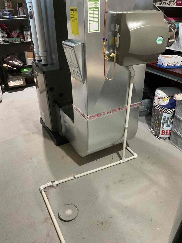 Completed full HVAC system installation including a 90,000 BTU high-efficiency furnace with humidifier and 3-ton air conditioning unit with rear discharge configuration. Installed Lennox condenser unit on exterior pad with proper electrical disconnect, refrigerant lines, and condensate drainage. Configured indoor furnace system in basement utility area with PVC venting, copper refrigerant tubing, and integrated humidification system. All mechanical permits obtained and equipment reconnected to existing ductwork and utilities per code requirements.