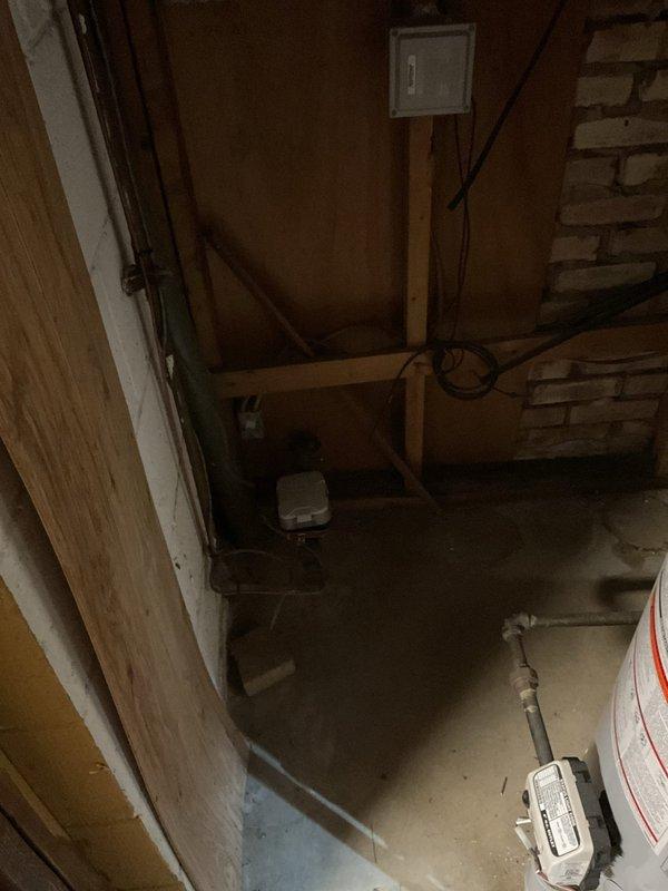 Conducted comprehensive electrical panel upgrade estimate in basement laundry room area. Assessed existing electrical panel box mounted on wall adjacent to laundry appliances, documented current panel configuration, examined overhead wiring runs along exposed ceiling joists, and evaluated junction box connections in utility space. Photographed electrical infrastructure including panel location, surrounding clearances, and access pathways to ensure accurate scope development for proposed panel upgrade work.