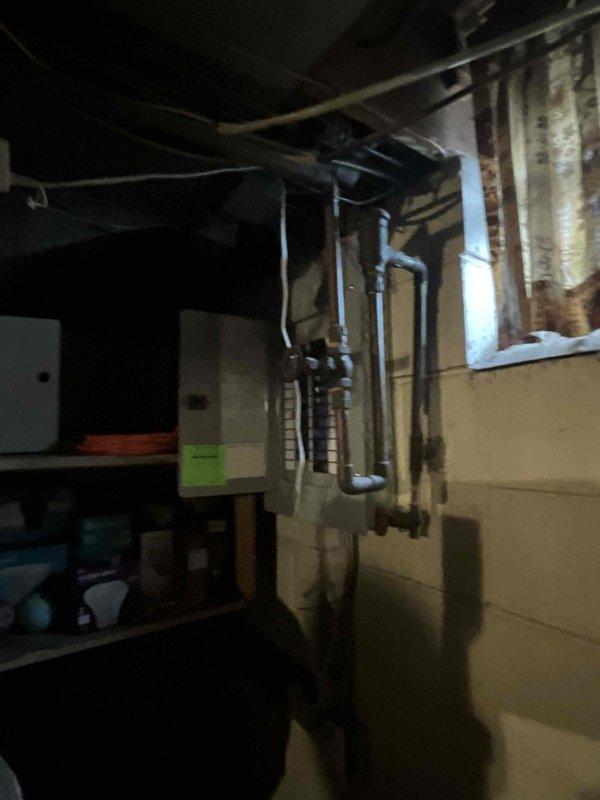 Conducted site evaluation for air conditioning system replacement in basement mechanical room where previous unit had been removed. Assessed existing ductwork configuration, electrical infrastructure, and available space constraints around furnace and water heater to determine proper equipment sizing and installation requirements for new cooling system.